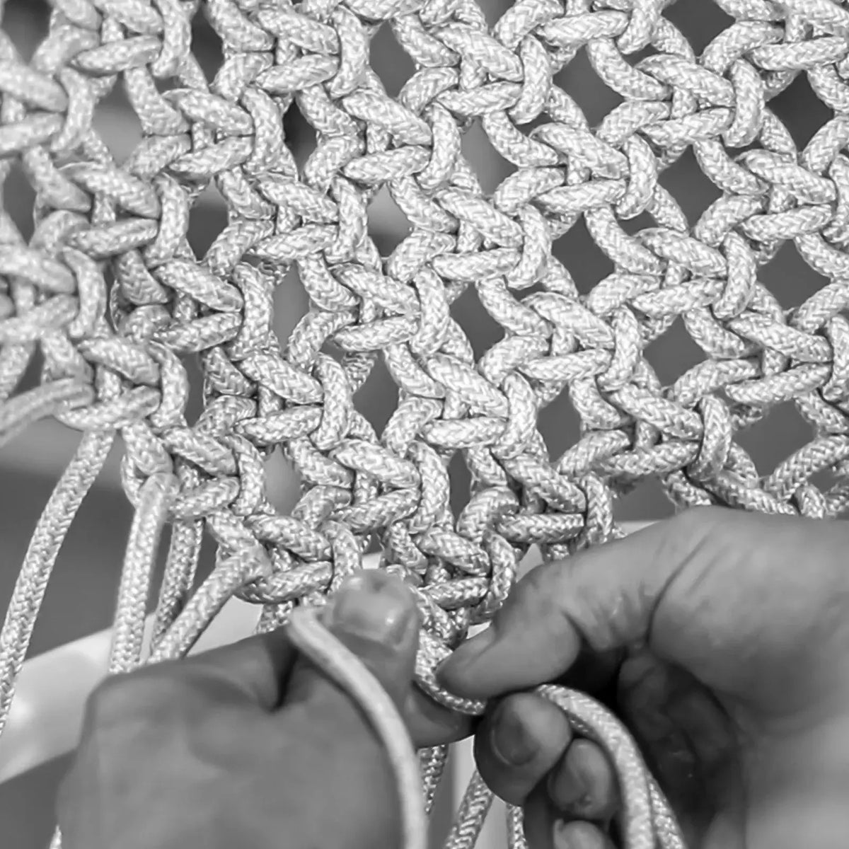 Hands knotting outdoor rope by hand