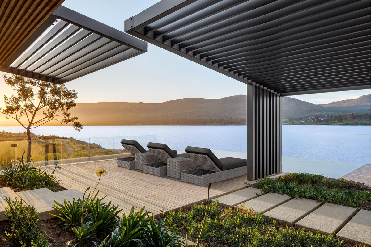 Monaco chaise lounges under a pergola overlooking a lake at sunset