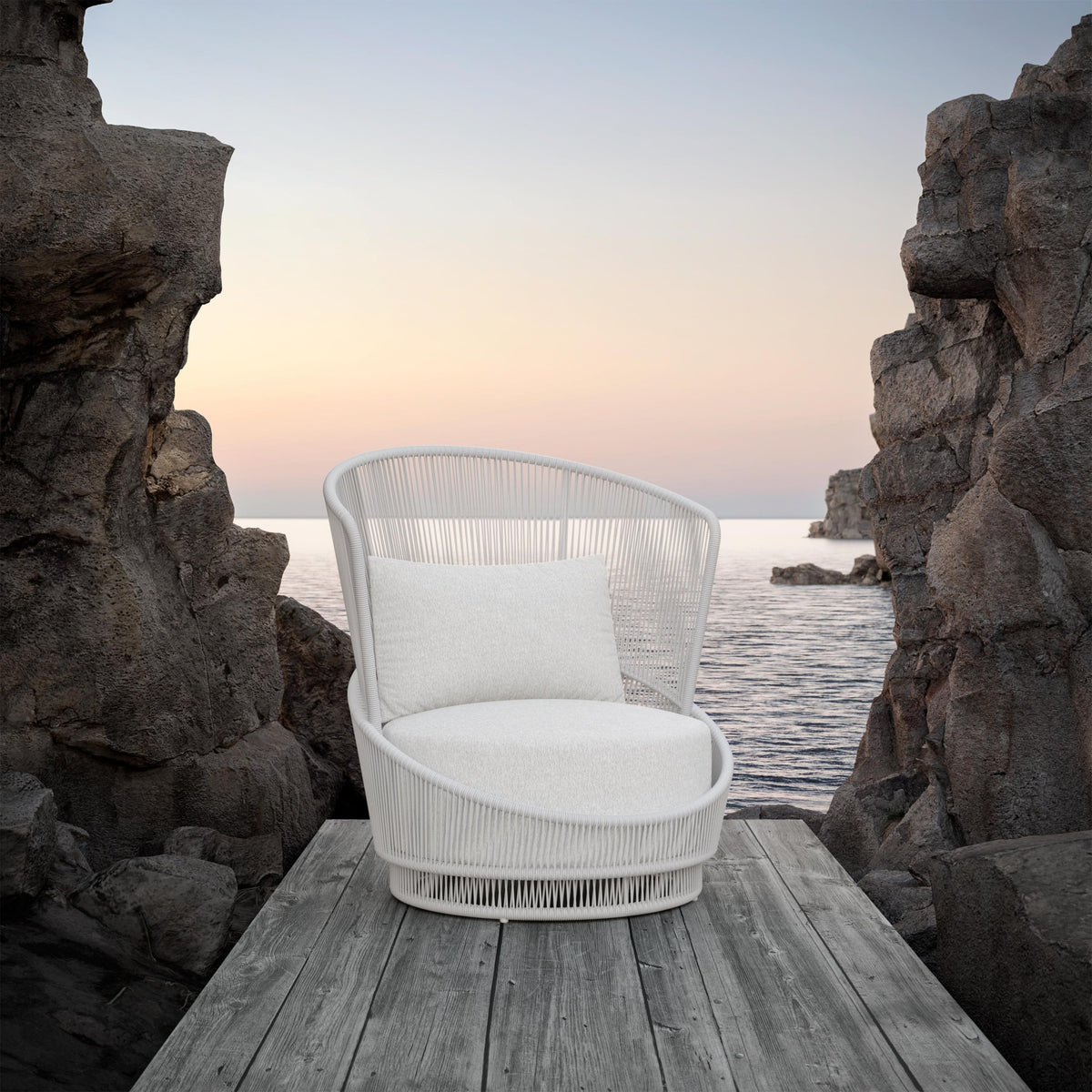 Palma swivel club chair in White Mist on a rocky shore